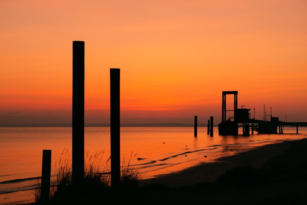 sunset at delta shore with pilings and water | GPS: 49.193125, -122.889187