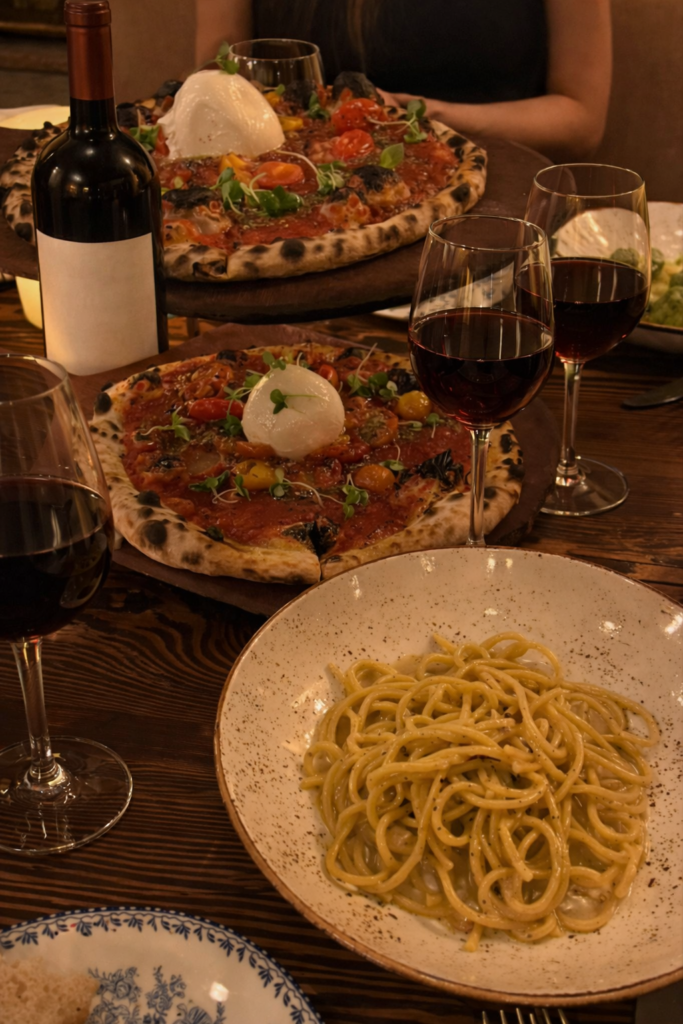 new-westminster-local-business-directory-professional-services-brewery-dining-scene-community-life-heritage-culture-recreation-wellness-italian-dining-table-with-pizza-pasta-and-red-wine-glasses