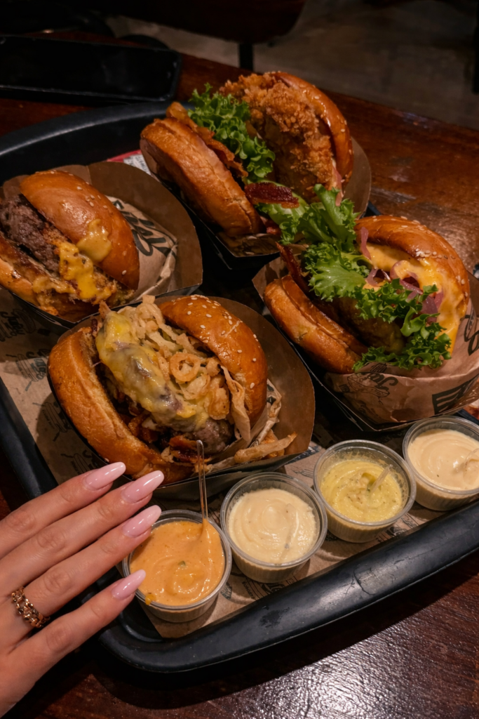 new-westminster-local-brewery-dining-scene-community-life-close-up-burger-tray-with-sauce-cups-and-girls-hand-with-acrylic-nails
