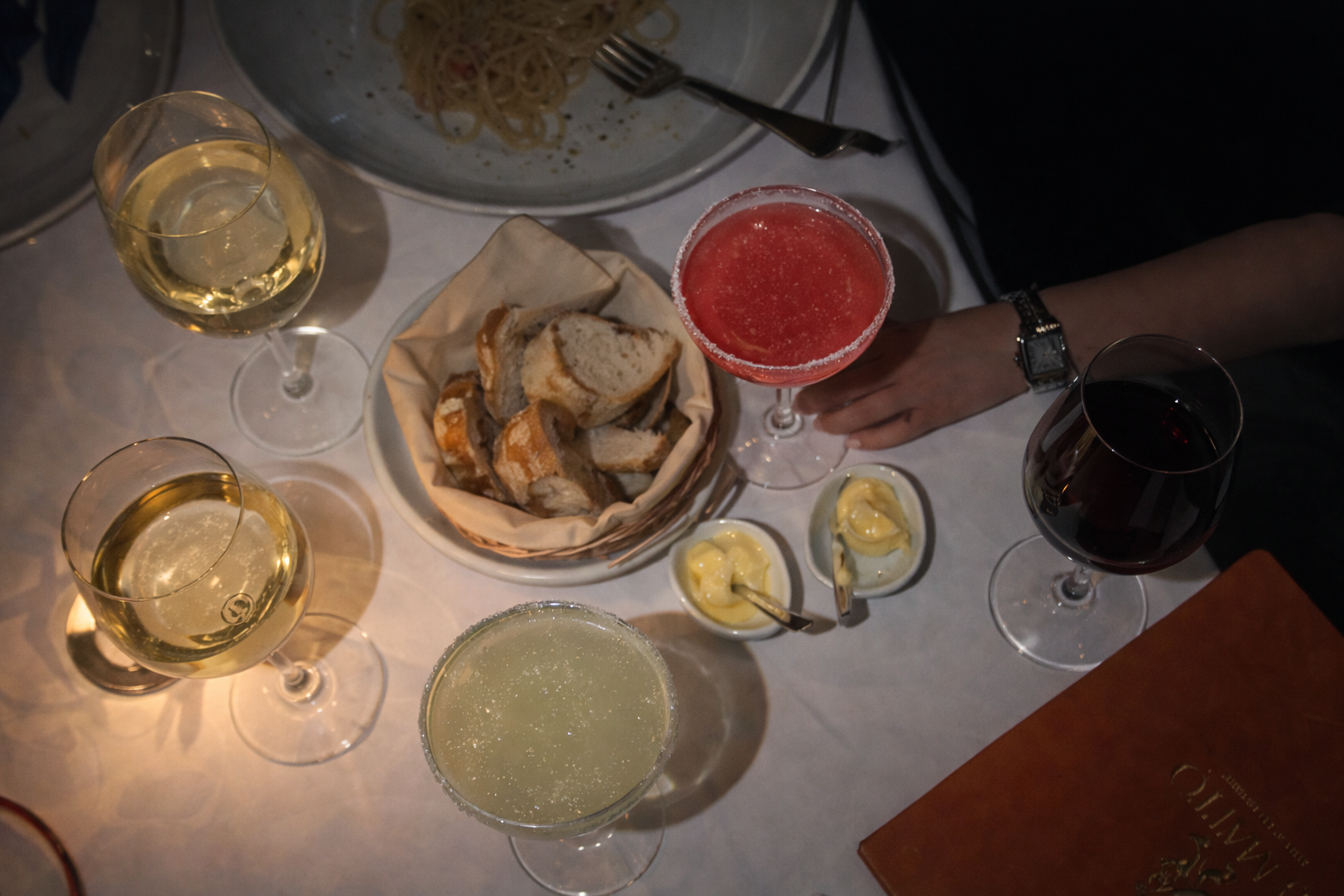 new-westminster-local-brewery-dining-scene-community-life-overhead-table-with-white-wine-red-wine-cosmopolitan-margarita-and-bread-with-butter