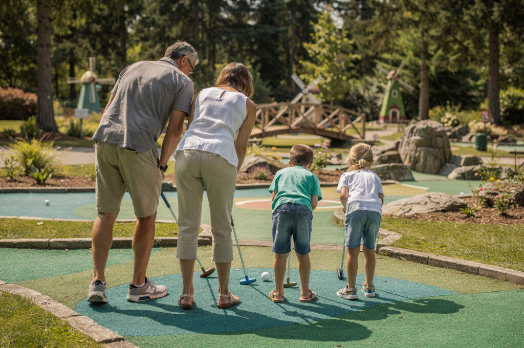 family playing mini golf together from behind at New Westminster mini golf course