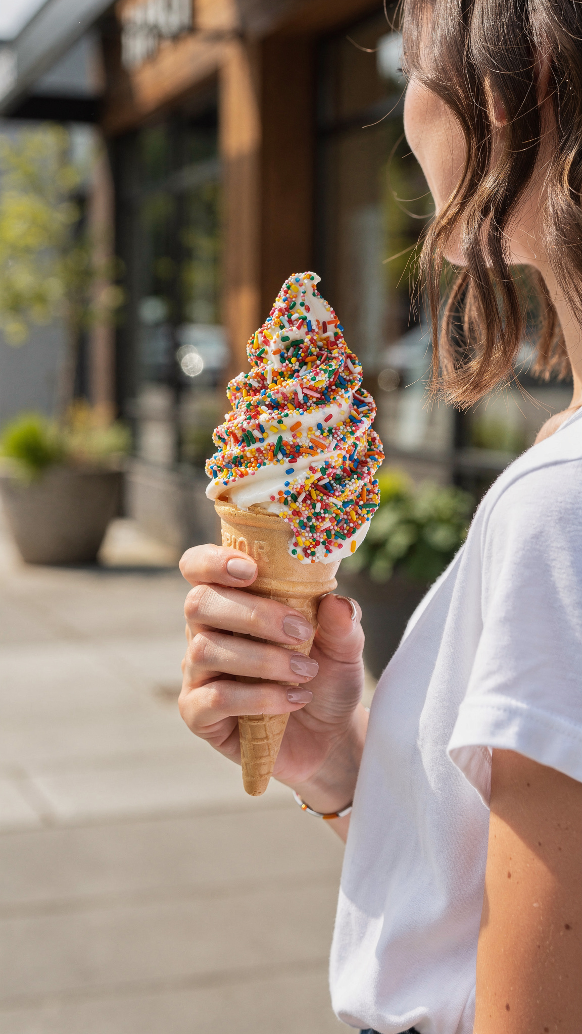 ice cream cone with sprinkles held streetside in New Westminster